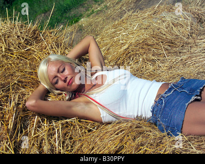Frau liegt im Stroh Stockfoto
