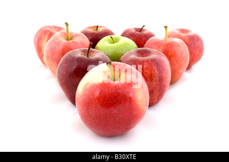 Ein grüner Apfel in einem Dreieck von roten Äpfeln Stockfoto