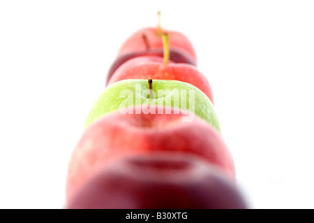 Ein grüner Apfel in einer Reihe von rot Stockfoto