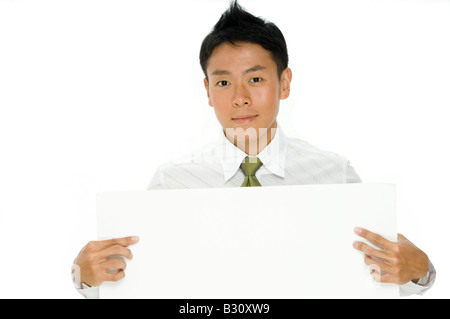 Ein junger chinesischer Geschäftsmann hält eine leere Schild Stockfoto