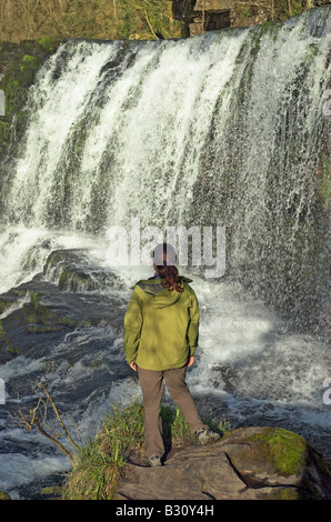 Eine einsame Frau am Wasserfall bei Ystradfellte in Brecon-Beacons-Wales Stockfoto