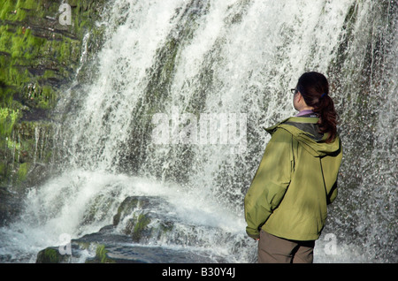 Eine einsame Frau am Wasserfall bei Ystradfellte in Brecon-Beacons-Wales Stockfoto