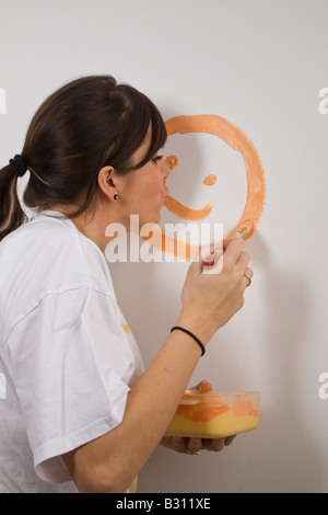 Junge Frau malt ihre Wohnung Stockfoto