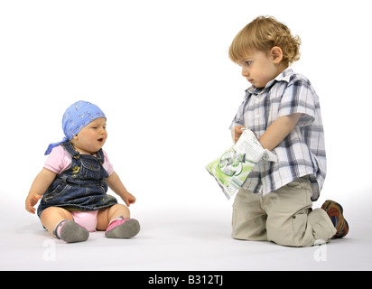 kleiner Junge mit Baby und Süßigkeiten Stockfoto