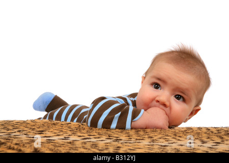 Porträt eines Babys liegen auf einer Decke mit Daumen im Mund Stockfoto