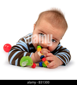 Baby mit Spielzeug auf dem Bauch liegend Stockfoto