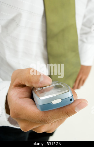 Eine Nahaufnahme von einer Hand hält ein kleines Handy Stockfoto