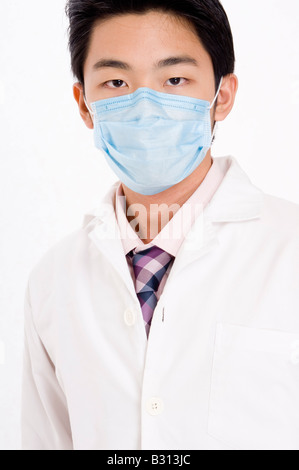 Ein junger asiatischer Mann in einem blauen Gesichtsmaske Stockfoto