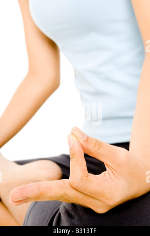 Eine junge Frau in einer Yogaposition sitzt und meditiert Stockfoto