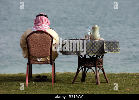 Arabische Mann sitzt an einem Tisch im freien Stockfoto