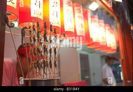 Wangfujing Nachtmarkt gastronomische Stände verkaufen exotische Snack Essen einschließlich Scorpions auf Stöcke in Peking, China. Stockfoto