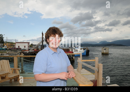 Darlene Thomas stehend auf dem Deck des Seaside Suites in Woody Point, Neufundland, ein Fischerdorf an der Bucht von Bonne. Stockfoto