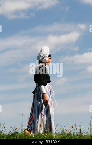 Holländerin am Deich mit traditioneller Kleidung Stockfoto