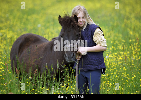 Junges Mädchen mit einem Pony auf einer Wiese Stockfoto