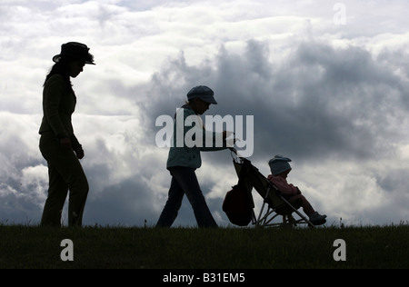 Silhouetten von einer Familie zu Fuß über ein Feld Stockfoto