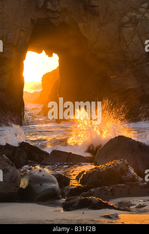 Ein Bogen am Big Sur s Pfeiffer Beach glüht wie Abendlicht durch seine Öffnung gießt Stockfoto