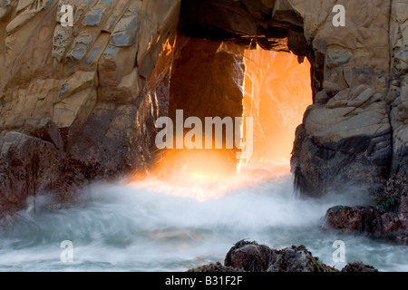 Ein Bogen am Big Sur s Pfeiffer Beach glüht wie Abendlicht durch seine Öffnung gießt Stockfoto