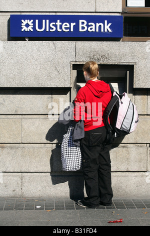 Eine junge Frau an einem Geldautomaten in Dublin, Irland Stockfoto