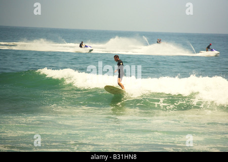 Menschen Surfen mit Jet-Ski im Hintergrund Stockfoto