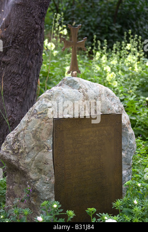 Georgische Zeichen auf dem alten Grabstein in der Nähe des Baumes Stockfoto