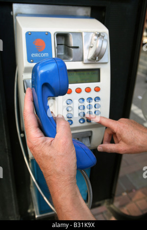 Man wählt ein öffentliches Telefon, Dublin, Irland Stockfoto