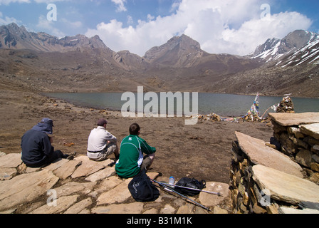 Trekker sitzen mit Blick auf den Eis-See in der Nähe von Manang, Annapurna Gebirge, Nepal Stockfoto