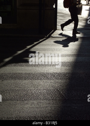 Person, die dunklen Schatten auf die Fahrbahn in der Stadt Stockfoto
