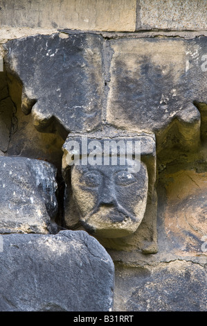 Detail der Corbel Fries aus Südwand geschnitzt von lokalen Mühlstein Korn mit grotesken Köpfe St. Johannes der Täufer Kirche Adel Stockfoto