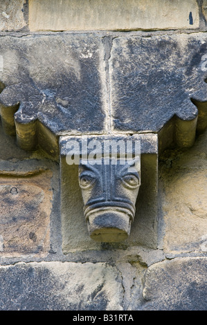 Detail der Corbel Fries aus Südwand geschnitzt von lokalen Mühlstein Korn mit grotesken Köpfe St. Johannes der Täufer Kirche Adel Stockfoto