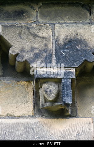 Detail der Corbel Fries aus Südwand geschnitzt von lokalen Mühlstein Korn mit grotesken Köpfe St. Johannes der Täufer Kirche Adel Stockfoto