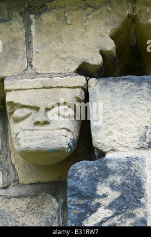 Detail der Corbel Fries aus Südwand geschnitzt von lokalen Mühlstein Korn mit grotesken Köpfe St. Johannes der Täufer Kirche Adel Stockfoto