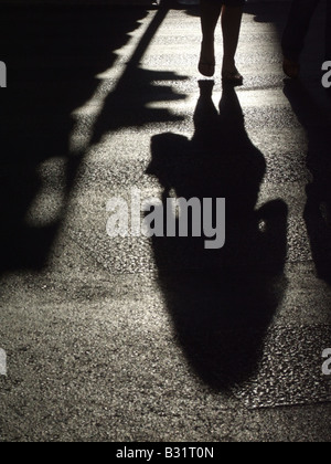 Person, die dunklen Schatten auf die Fahrbahn in der Stadt Stockfoto