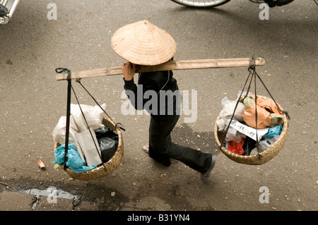 Ein Blick von oben von einem Straßenhändler tragen Körbe auf einem Schulter-Mast in Hanoi Vietnam ausgesetzt Stockfoto