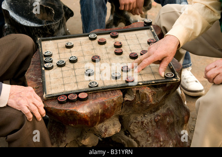 Der alte Mann die Hände auf ein Brettspiel in Hanoi, Vietnam gespielt von zwei älteren Vietnamesische Männer Stockfoto