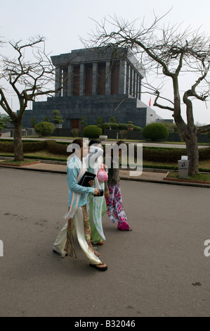 Vietnamesische Frauen tragen traditionelle Ao Dai Seide Tuniken gehen vorbei Ho Chi Minh Mausoleum in Hanoi Vietnam Stockfoto