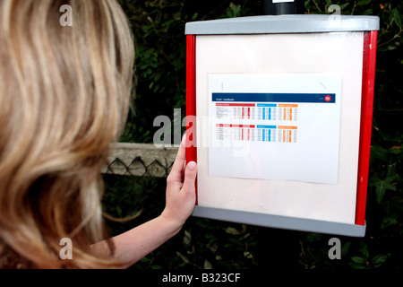 Junge Frau wartet ein Busmodell veröffentlicht Stockfoto