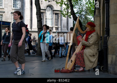 Harfenistin Brenda Malloy als Straßenmusikant außerhalb am Trinity College Dublin Stockfoto