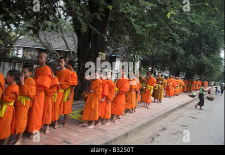 Lao Mönche empfangen Morgen Almosen in der Weltkulturerbe Stadt Luang Prabang in Laos. Stockfoto