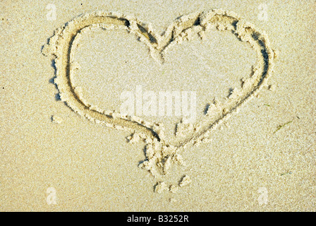 Herzen auf Sand am Meeresstrand gezogen Stockfoto