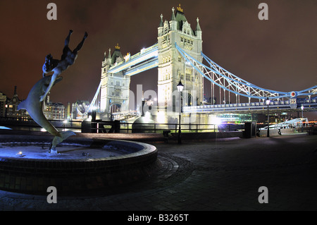 Frau Schwimmen mit Delphinen mit Blick auf London Tower Bridge Stockfoto