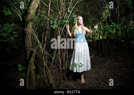 Junge Frau, die zu Fuß in eine märchenhafte Wälder mit Müll herum Stockfoto