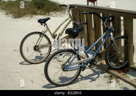 Strand Fahrräder geparkt im sonnenbeschienenen Sand Stockfoto