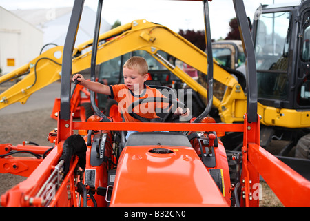 Kleiner Junge spielt auf Traktor Stockfoto