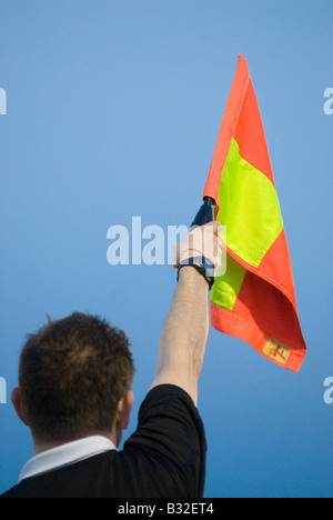 Linienrichter hält Flagge Stockfoto