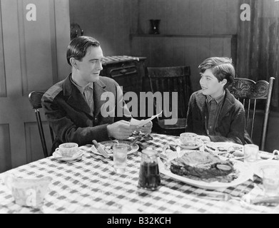 Porträt von Vater und Sohn am Esstisch Stockfoto