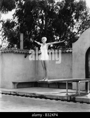Frau auf Sprungbrett im Schwimmbad Stockfoto