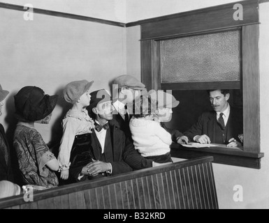 Familien, die in der Schlange am Fenster Stockfoto