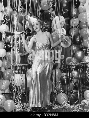 Frau feiert mit Raum voller Luftballons Stockfoto