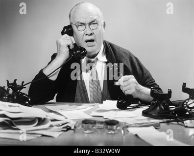 Mann auf mehreren Telefonen suchen wütend Stockfoto