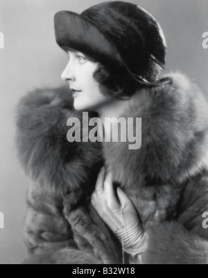 Profil von eine elegante Frau in einem Pelzmantel und satin Hut Stockfoto